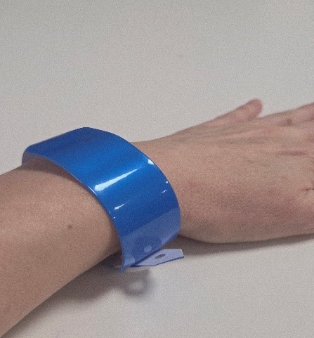 Image of a blue wristband around a wrist.